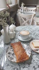Enjoying a cozy moment with coffee and pastry at a charming cafe with elegant decor