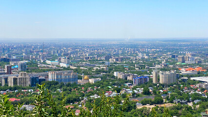 Naklejka premium Tourism in Kazakhstan. View of a green city with lots of buildings and polluted air. Almaty, Kazakhstan. View from the top of Kok-Tobe Park