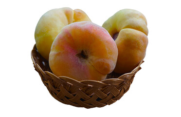 Ripe flat peaches in a basket on a white background