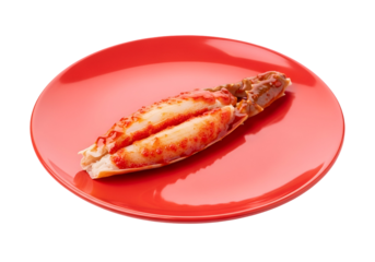 Prepared crab legs on a vibrant red plate against a stark black background.