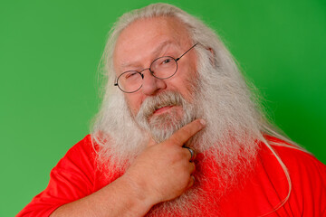 Older man with long white beard and glasses poses playfully against a bright green background...