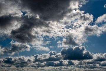 Dramatischer, kontrastreicher Wolkenhimmel mit durch die Wolken scheinenden Sonnenstrahlen der...