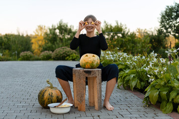 Young woman carving a pumpkin for Halloween in her backyard