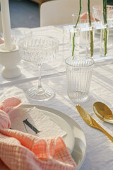 Elegant outdoor wedding reception decorated with flowers and glassware.