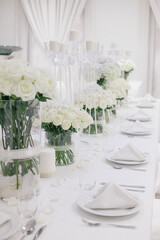 Long wedding banquet table with elegant white floral arrangements.