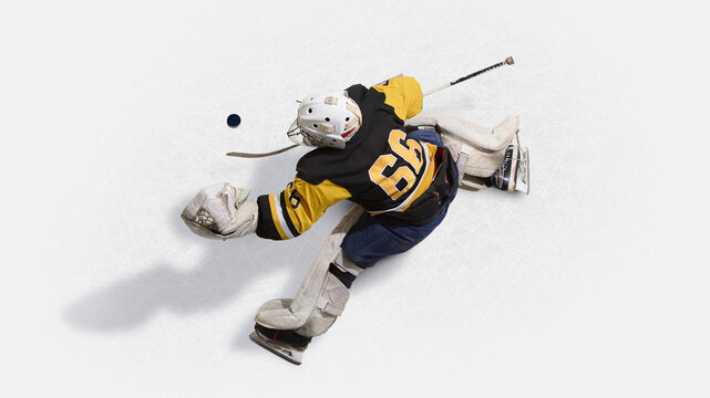 Overhead view hockey goalkeeper in yellow jersey leaping to block puck. Concept of isometric, reflexes, athleticism, determination, protection, and emotional intensity in sports.