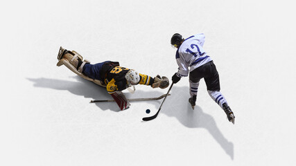 Aerial top view hockey goalkeeper diving across ice to stop rival with desperation. Concept of sacrifice, struggle, rivalry, isometric, drama, and emotional pressure in competition.