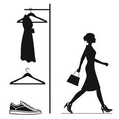 Woman walking with shopping bag and dresses on hangers
