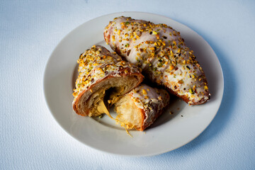 Pistachio croissant on a plate with a blue tint.