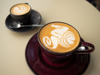 Two cups of coffee with latte art on a table