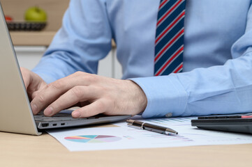 Economics and finance, a businessman sits at a computer and calculates something, fills out...
