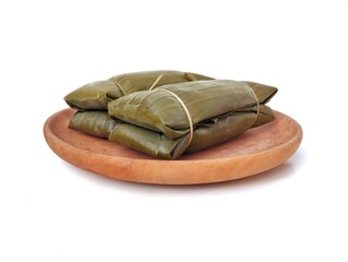 Pesor or Indonesian traditional food made from rice and wrapped in banana leaves on wooden plate...