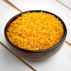 Wooden bowl with golden bulgur wheat.