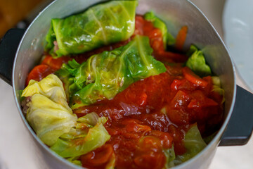 Cabbage rolls simmering in a pot with rich tomato sauce, prepared with fresh ingredients