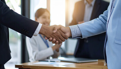 Business partners shaking hands as a sign of agreement. The photo symbolizes a successful business deal