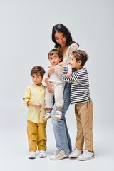 Young mother joyfully embraces her adorable children in a warm family moment