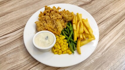 Delicious Crispy Fried Chicken Steak with French Fries and Vegetable Dish. Perfect for culinary...