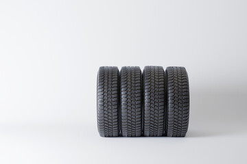 Image of a neatly arranged stack of four car tires, highlighting their tread patterns and robust...