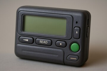 Fototapeta premium Close up of a vintage dark gray pager with a green screen and buttons, evoking nostalgia for simpler times in communication technology