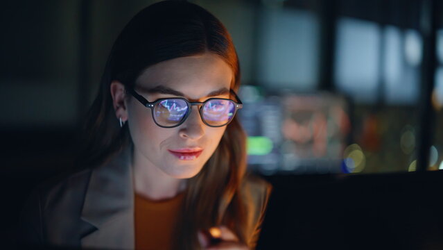 Woman stockbroker working late at night reviewing charts on computer closeup - Powered by Adobe