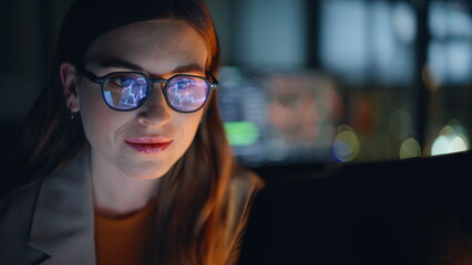 Late evening analyst examining currency fluctuations on notebook device closeup