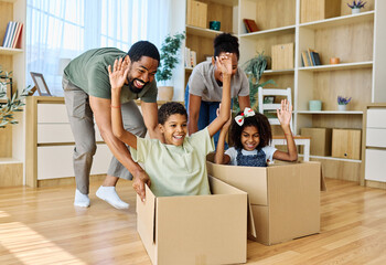 Famili of four, Father and mother  pushing their son and  daughter sitting in a cardboard box,...