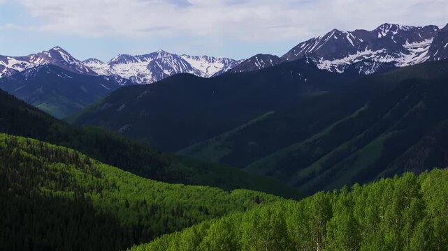 Ashcroft Mountain ghost town spring summertime morning blue sky clouds Aspen Mountain Ajax Little Annie Trailhead aerial drone Colorado scenic Rocky Mountains Elk Range Aspen Trees pan left motion