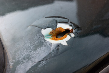 Damaged vehicle marked by gunfire in war