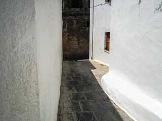 Quiet  streets lead down from ruins of Acropolis to city centre in the Lindos city on Rhodes island...