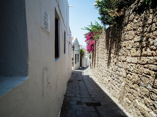 Quiet  streets lead down from ruins of Acropolis to city centre in Lindos city on the Rhodes island...