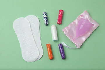Obraz premium feminine pads, tampons, menstrual cup feminine hygiene products on a green background 