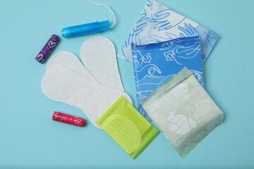 feminine pads, tampons, menstrual cup feminine hygiene products on a blue background
