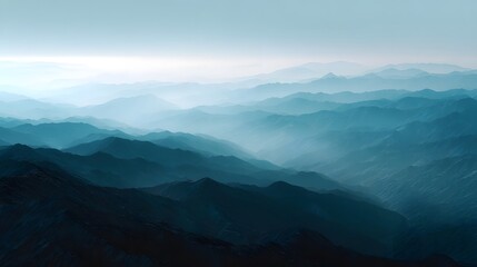 Fototapeta premium Layered blue mountain ridges fade into atmospheric haze under a soft bright sky