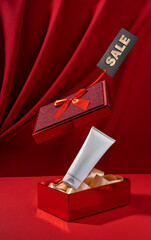 White bottle cosmetic product in red giftbox levitate on red background. mock up design for advertising, seasonal discounts.