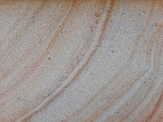 Natural sandstone texture with soft beige and brown wavy patterns, perfect for backgrounds and...