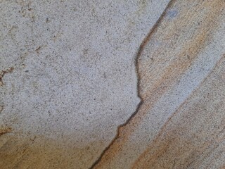 Natural sandstone texture with soft beige and brown wavy patterns, perfect for backgrounds and...