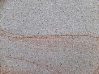 Natural sandstone texture with soft beige and brown wavy patterns, perfect for backgrounds and...