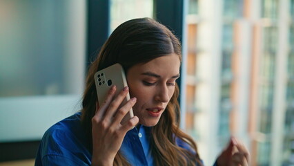 Emotional businesswoman arguing mobile phone in modern private office closeup