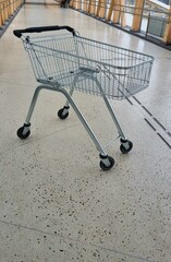 close-up of metal shopping cart on cement floor in store, business concept, process in vintage tone