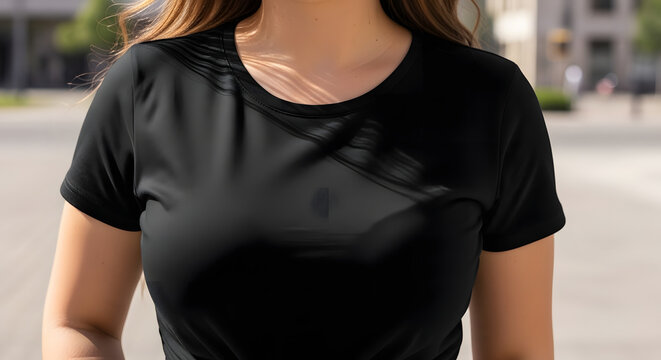 Close-up of a woman in a black t-shirt outdoors, with a blurred city background
