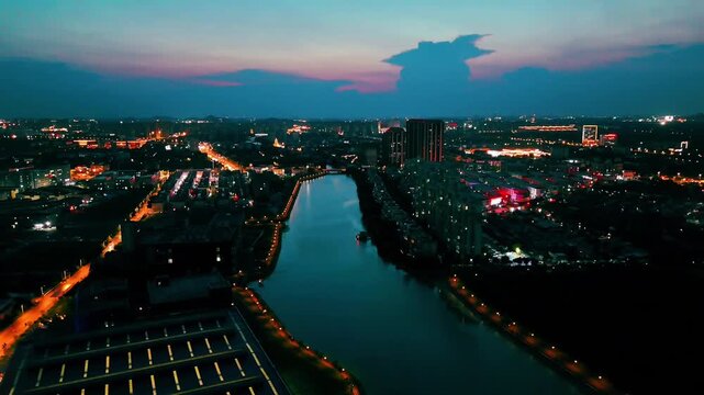 Drone aerial video of the city river and illuminated streets at night