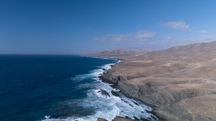 Obraz premium This is a high-angle aerial view of a coastline, showing the striking contrast between the ocean and the land.