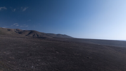 `Desert Track Through Volcanic Hills Under Clear Sky – Remote Arid Landscape