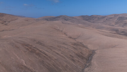 Desert Track Through Volcanic Hills Under Clear Sky &ndash; Remote Arid Landscape