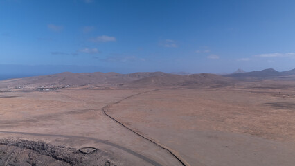 Desert Track Through Volcanic Hills Under Clear Sky &ndash; Remote Arid Landscape