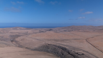 Desert Track Through Volcanic Hills Under Clear Sky &ndash; Remote Arid Landscape