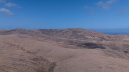 Desert Track Through Volcanic Hills Under Clear Sky – Remote Arid Landscape