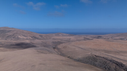 Desert Track Through Volcanic Hills Under Clear Sky &ndash; Remote Arid Landscape