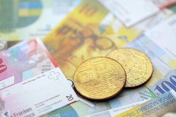 Swiss franc banknotes and bitcoin. The current francs money bills and bit coin lies on table