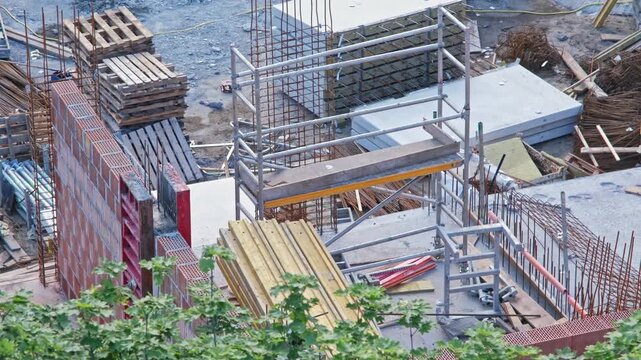 Messy Construction Site of Office and Residential Building with Rebar Reinforcement and Precast Concrete Slabs Corrugated Pipes and Wooden Formwork